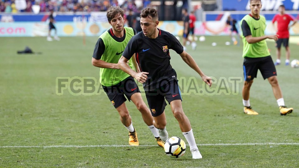 Các cầu thủ tập luyện nghiêm túc dưới sự chứng kiến của đám đông khán giả.