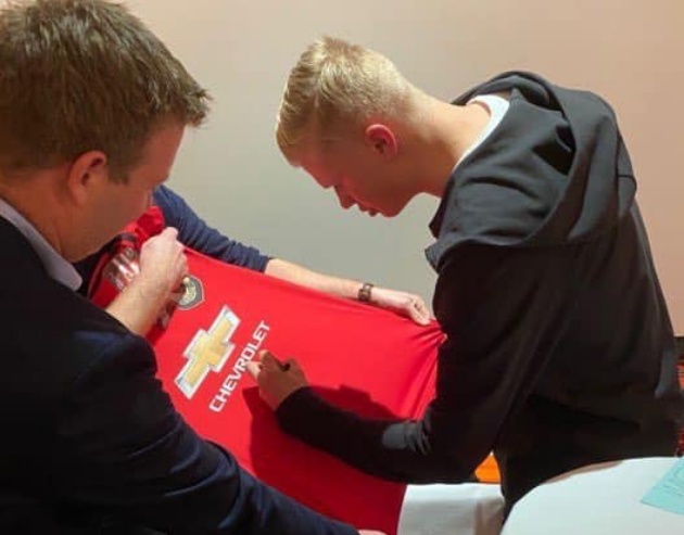 Haaland ký tên lên áo đấu Man United.
