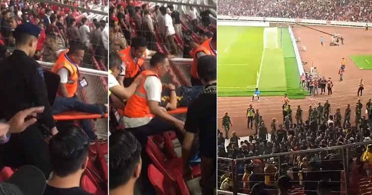 CĐV Malaysia được cảnh sát đưa đi cấp cứu trên sân Bung Karno. Ảnh: The Star.