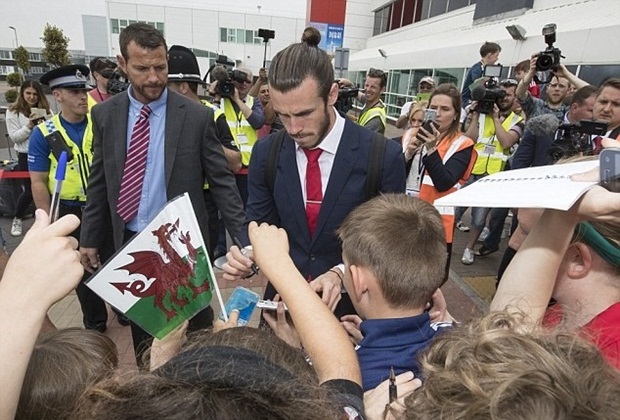  Trước khi lên máy bay, cầu thủ ký tặng cho người hâm mộ. Siêu sao Gareth Bale đương nhiên là trung tâm chú ý.