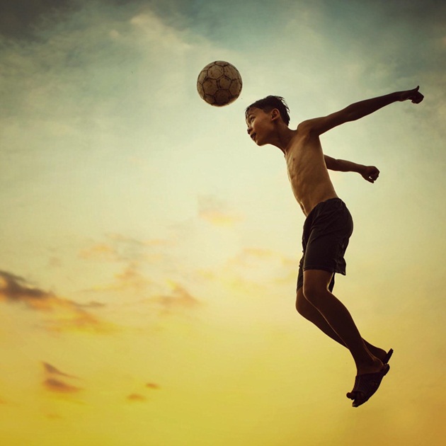 "Dưới ánh nắng chiều hè, cậu bé mải mê vui với trái bóng tròn mùa World Cup". Ảnh: Trần Tuấn Anh.