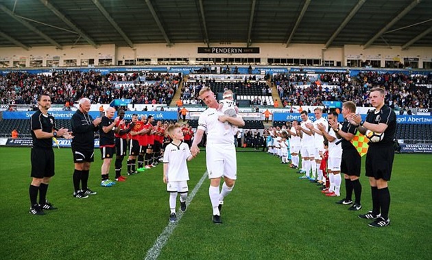 Đây là Alan Tate - người từng là người của Quỷ đỏ trước khi chuyển tới Swansea vào năm 2002. Được biết, trận đấu này được tổ chức nhằm tôn vinh những đóng góp của Tate trong quá khứ cho cả hai CLB.