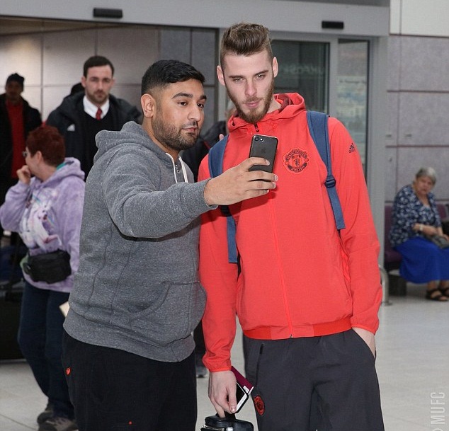 Thủ thành David De Gea tranh thủ chụp ảnh cùng NHM trước giờ bay.