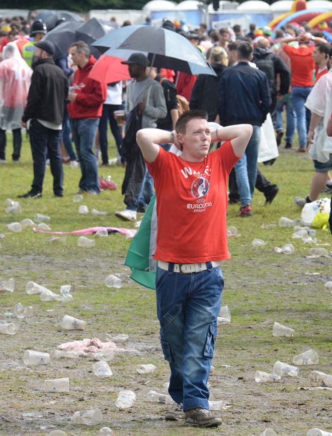 Sau trận thua Anh 1-2, một CĐV xứ Wales rất buồn khi đứng giữa khu đất với nhiều hộp nhựa đã được sử dụng. Ảnh: Internet.