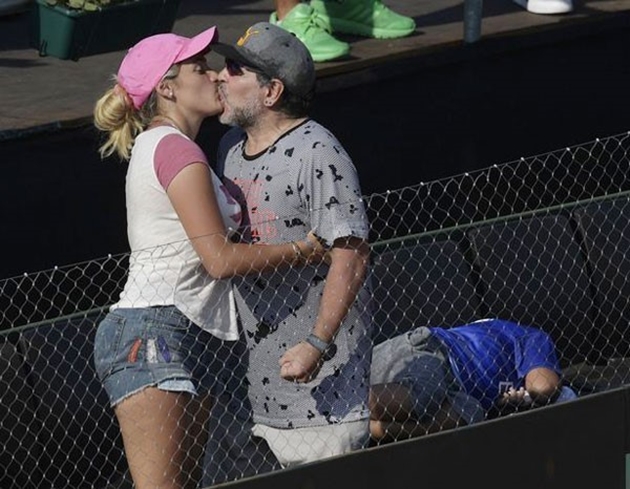 Mới đây, huyền thoại bóng đá người Argentina và bạn gái xuất hiện trên khán đài trận tennis giữa đội Italy với đội Argentina ở Davis Cup. Trong lúc khóa môi người tình trẻ, Maradona gồng cứng người, bàn tay tạo nắm đấm.