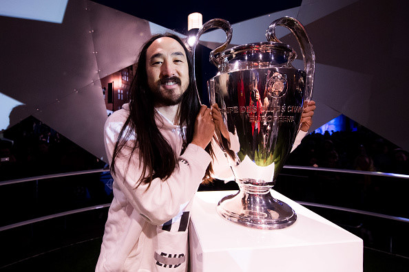 DJ lừng danh người Mỹ gốc Nhật Bản chụp ảnh lưu niệm bên chiếc cúp Champions League.