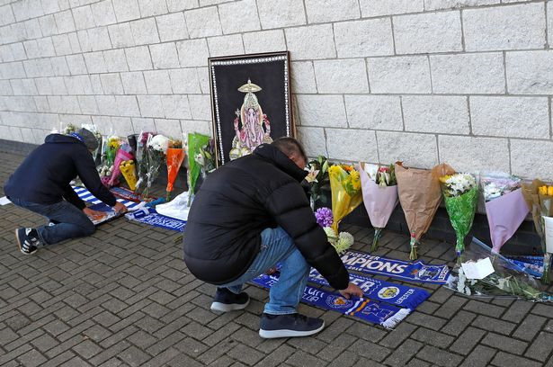 Các CĐV đặt những bó hoa và khăn của CLB để hy vọng chủ tịch CLB gặp may mắn.