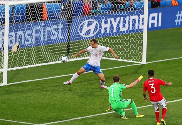 Thủ môn Igor Akinfeev không thể chặn được cú sút lần 2 của Neil Taylor. Ảnh: Internet.