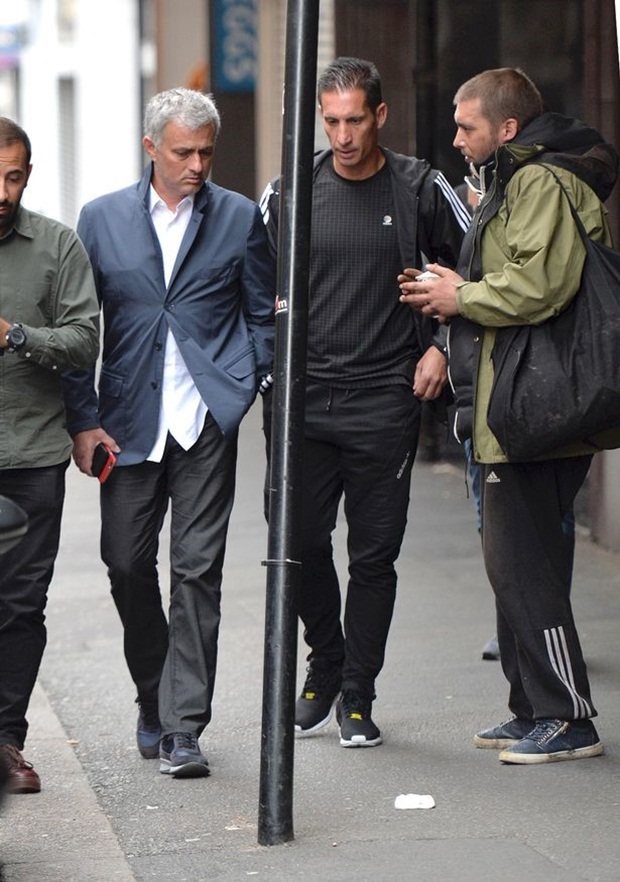 Khi bộ đôi HLV Manchester United đang thảnh thơi dạo bước, bất chợt 1 người đàn ông vô gia cư khoác túi đen tiến lại gần. Ảnh: Internet.
