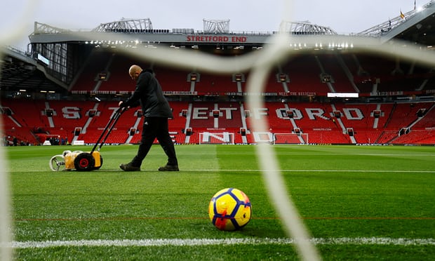 Các nhân viên chăm sóc mặt cỏ Old Trafford trước giờ bóng lăn