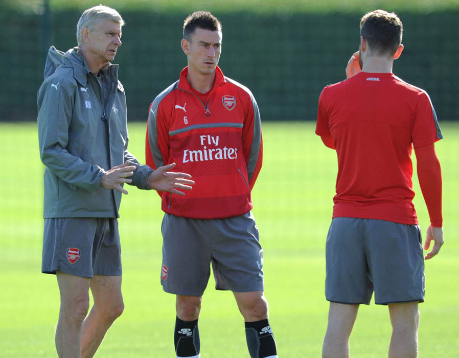 Wenger dặn dò những trung vệ rất kĩ càng trước trận đấu quan trọng ngày mai. Ảnh: Internet.