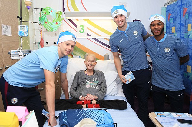 Oleksandr Zinchenko, Raheem Sterling và John Stones chụp hình cùng một bệnh nhân có hoàn cảnh không may.