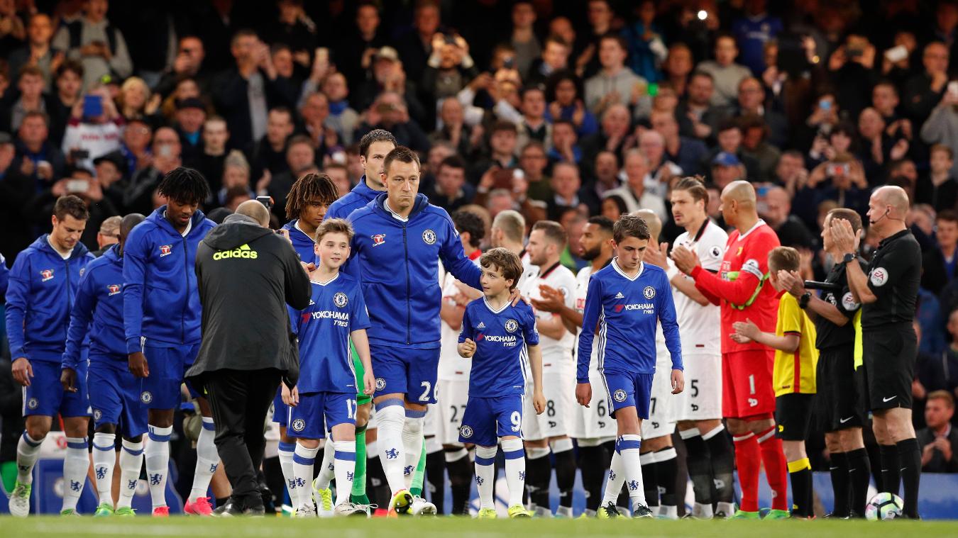 Đầu trận, anh đã oai phong, dẫn đầu đoàn quân vô địch bước vào sân trong tràng pháo tay của các cầu thủ Watford.