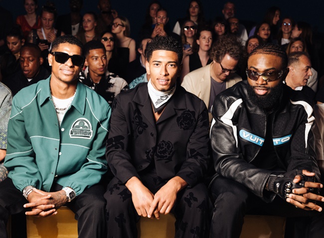 Marcus Rashford, Jude Bellingham và Jaylen Brown tại buổi trình diễn của Louis Vuitton năm ngoái. Bellingham cũng mang theo chiếc túi vải thô Keepall Bandouliere 45 cổ điển của Louis Vuitton khi trình diện để làm nhiệm vụ quốc tế trước thềm EURO 2024.