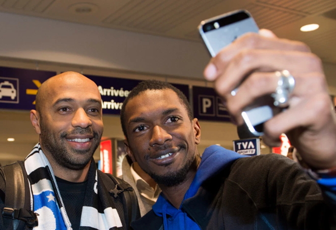 Thierry Henry hugs fans and poses for selfies at Montreal airport as Arsenal legend arrives in Canada for manager job - Bóng Đá