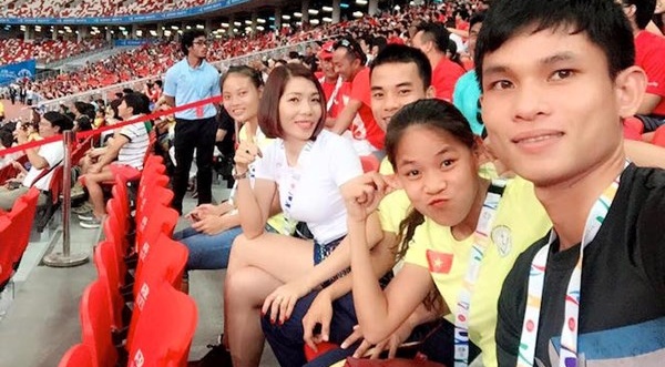 Vũ Thị Hương (áo trắng) ngồi trên khán đài theo dõi các đàn em thi thố ở nội dung 100m - Ảnh: Hoàng Quỳnh.