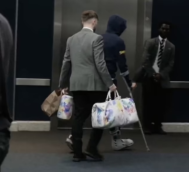 James Maddison is pictured on crutches and wearing a protective boot - Bóng Đá