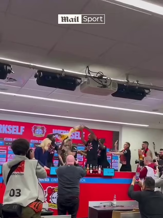 Xabi Alonso is covered in beer as his jubilant Bayer Leverkusen players gate-crash his post-match press conference - Bóng Đá