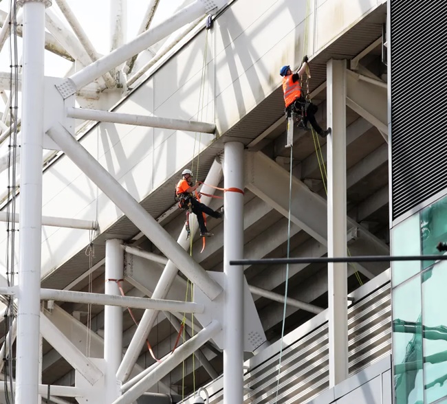 Workers scale Old Trafford to look at leaky roof after Man Utd stands were soaked by WATERFALL - Bóng Đá