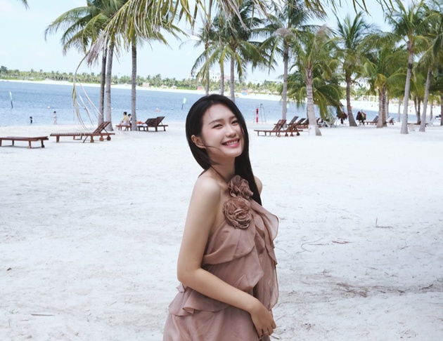 Doãn Hải Mỹ với nụ cười tỏa nắng trên bãi biển.