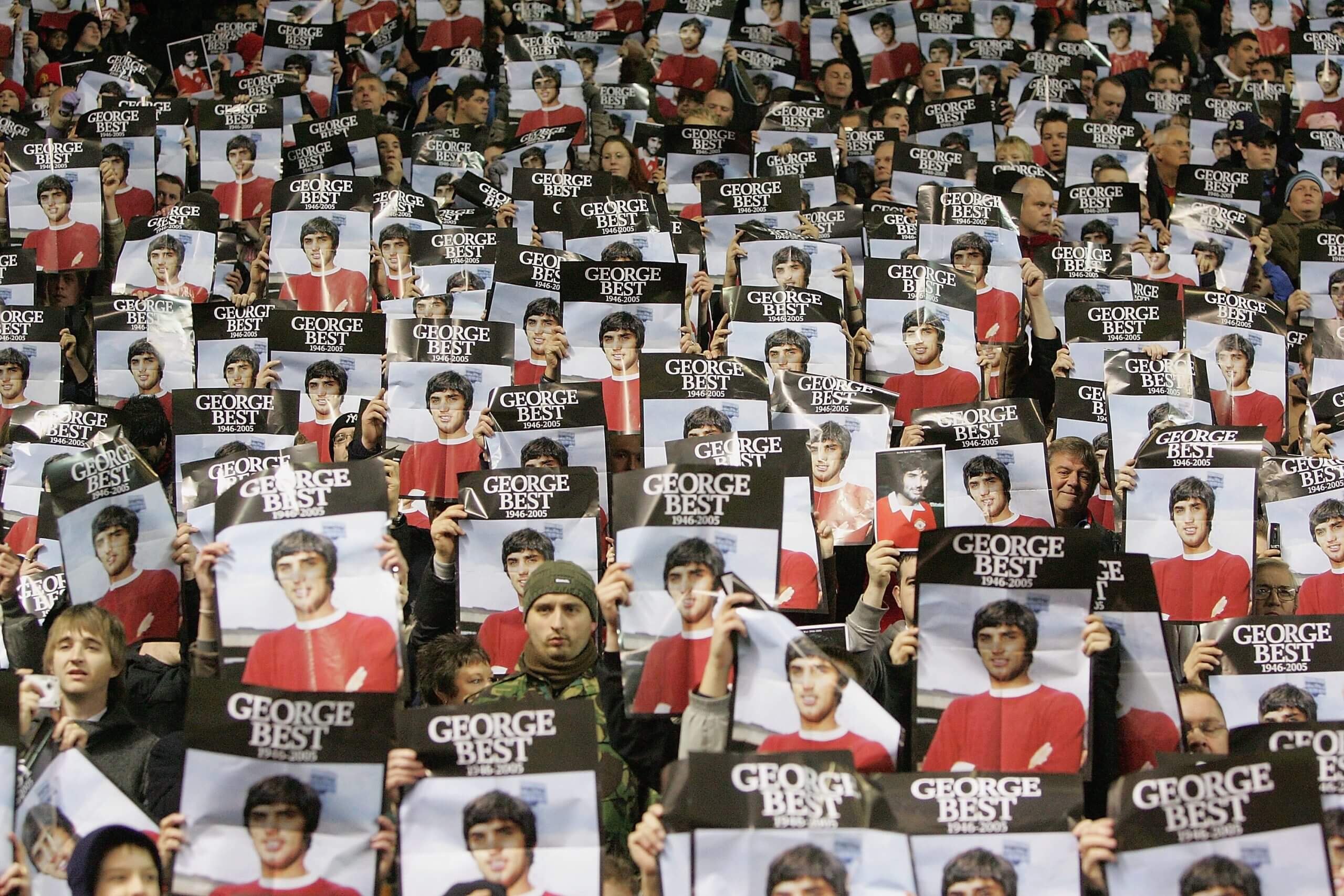 Người hâm mộ giơ cao tấm áp phích vinh danh George Best trước trận đấu với West Brom năm 2005