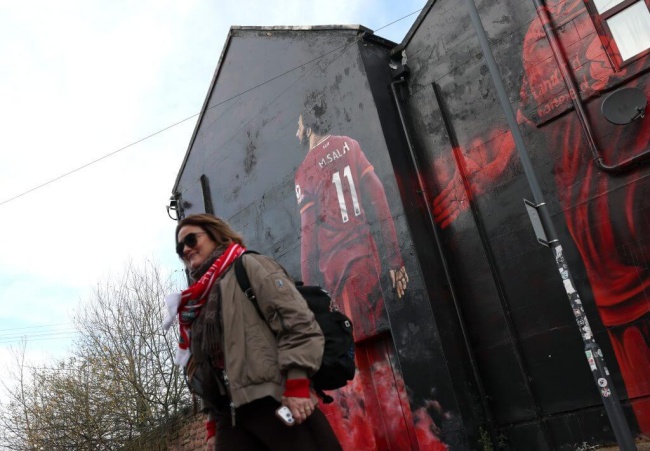 Một CĐV chụp h&igrave;nh b&ecirc;n cạnh bức tranh tường Salah.