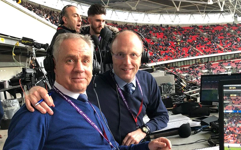 B&igrave;nh luận vi&ecirc;n Peter Drury (phải) v&agrave; người bạn đồng h&agrave;nh Jim Beglin (tr&aacute;i) trong một trận đấu Ngoại hạng Anh.