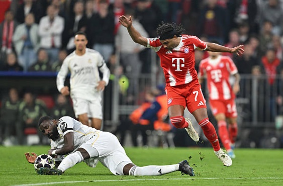 Trung vệ: Antonio Rudiger (5.2). Đây là một trong những trận đấu dưới sức của trung vệ người Đức. Rudiger liên tục bị lôi kéo khỏi vị trí bởi sự cơ động của các chân sút Bayern. Anh nhận một thẻ vàng và chịu trách nhiệm một phần trong việc không kèm chặt người ở tình huống gỡ hòa của đối thủ.

Trung vệ: Eder Militao (5.6). Militao chơi nỗ lực trong các tình huống tranh chấp tay đôi nhưng lại thiếu tập trung trong pha bóng dẫn đến bàn thắng của Harry Kane. Tấm thẻ vàng phải nhận trong hiệp hai cho thấy sự lúng túng của anh trước áp lực tấn công dồn dập từ phía đội chủ nhà.

Hậu vệ phải: Trent Alexander-Arnold (6.4). Cầu thủ người Anh thể hiện hai bộ mặt trái ngược. Ở mặt trận tấn công, anh có những đường chuyền dài mang thương hiệu tạo ra sự đột biến cao cho Real. Tuy nhiên, khả năng phòng ngự của Trent vẫn là điểm yếu khi anh thường xuyên bị khai thác khoảng trống sau lưng.

Tiền vệ: Arda Guler (7.3). Nhân vật chính trong lối chơi của Real Madrid. Guler khởi đầu bùng nổ với cú đúp đẳng cấp, bao gồm một pha dứt điểm tinh quái và một cú sút phạt thần sầu. Tuy nhiên, tấm thẻ đỏ ở cuối trận là điểm trừ.

Tiền vệ: Federico Valverde (6.0). Valverde vẫn duy trì sự nhiệt huyết thường thấy với nguồn năng lượng vô tận ở khu vực trung tuyến. Anh đóng vai trò quan trọng trong việc luân chuyển bóng và hỗ trợ phòng ngự, nhưng không thể giúp Real Madrid kiểm soát hoàn toàn thế trận trước hàng tiền vệ cơ động của Bayern.

Tiền vệ: Jude Bellingham (6.2). Một trận đấu tròn vai nhưng thiếu sự bùng nổ thường thấy của ngôi sao người Anh. Bellingham hoạt động rộng trong vai trò box-to-box, tích cực tranh chấp và phát động tấn công, song anh thiếu đi những khoảnh khắc quyết định để giúp đội khách tạo nên khác biệt.

Tiền vệ: Brahim Diaz (6.9.) Diaz chơi đầy nỗ lực trong khoảng thời gian có mặt trên sân. Anh tạo ra một vài cơ hội nguy hiểm nhờ kỹ thuật cá nhân lắt léo và sự sáng tạo trong các pha phối hợp nhỏ. Sự hiện diện của anh giúp lối đá tấn công của Real thanh thoát hơn nhiều trong hiệp một.

Tiền đạo: Kylian Mbappe (7.1). Mbappe cho thấy đẳng cấp với một bàn thắng quan trọng sau tình huống phản công sắc lẹm. Tốc độ của anh luôn là mối đe dọa thường trực đối với hàng thủ Bayern, dù đôi khi anh có thể chơi đồng đội hơn trong các pha xử lý cuối cùng để tối ưu hóa cơ hội.

Tiền đạo: Vinicius Junior (7.0). Ngôi sao người Brazil để lại dấu ấn đậm nét với pha kiến tạo dọn cỗ cho Mbappe lập công. Anh suýt chút nữa đã có bàn thắng cho riêng mình nếu cú dứt điểm cuối hiệp một không tìm đến đúng xà ngang. Sang hiệp hai, Vinicius thi đấu nỗ lực nhưng bị các hậu vệ đối phương chăm sóc quá kỹ.

Eduardo Camavinga (4.4): Vào sân thay cho Brahim Diaz ở phút 60. Tiền vệ người Pháp khởi đầu đầy hứa hẹn nhưng ngay sau đó đã có một khoảnh khắc thiếu kiềm chế, nhận tấm thẻ vàng thứ hai khiến Real Madrid lâm vào thế mất người và sụp đổ ở cuối trận.