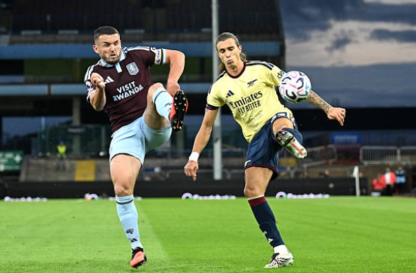 McGinn phạm lỗi với Calafiori. Ảnh: Stuart MacFarlane/Arsenal FC via Getty Images.
