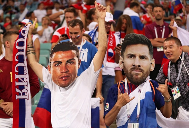 Người hâm mộ đeo mặt nạ Ronaldo và Messi. Ảnh: EPA.