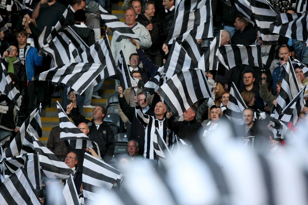 CĐV Newcastle v&agrave; m&agrave;u cờ sọc đen trắng đặc trưng. Ảnh: EPA.